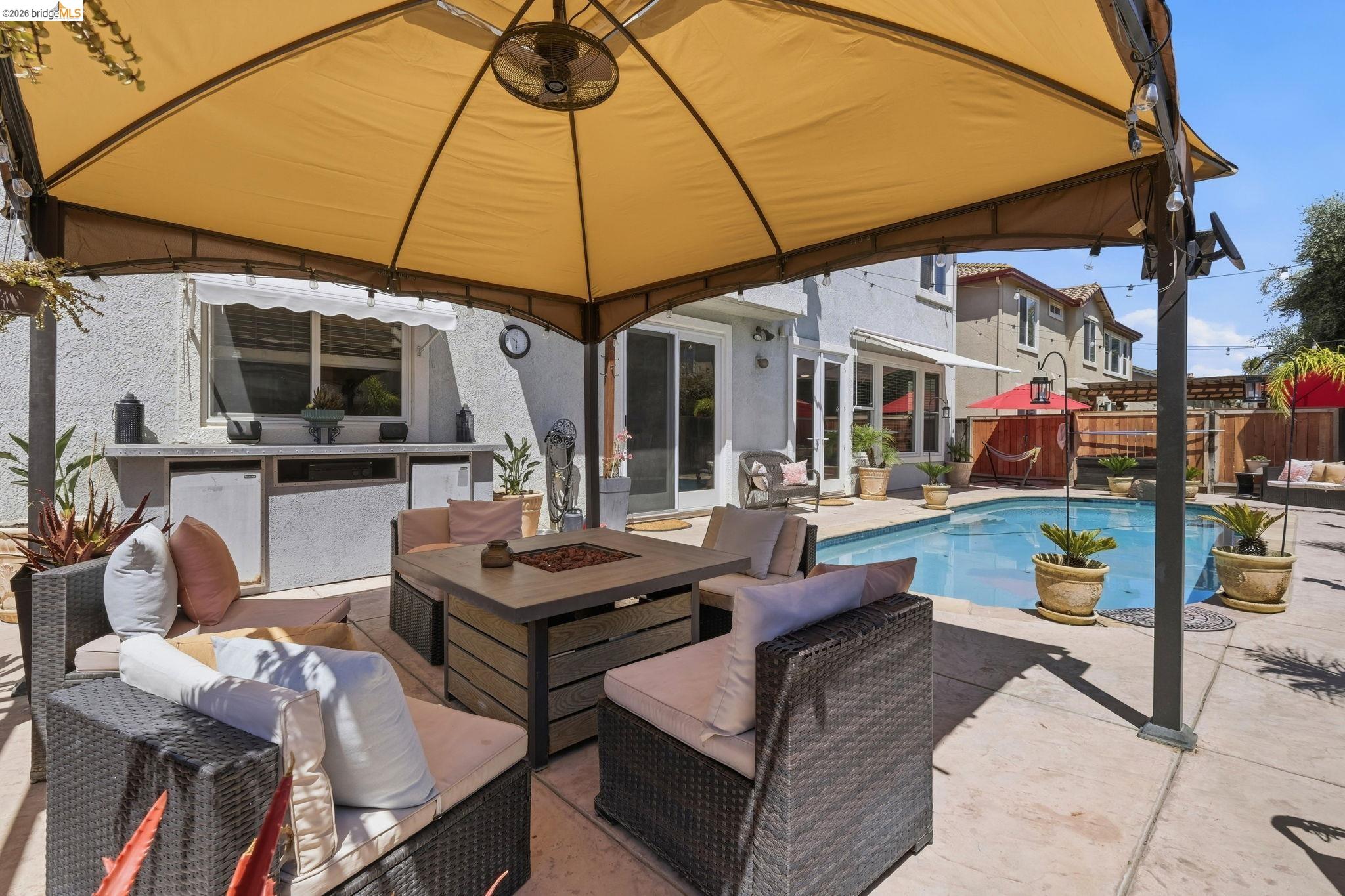 3438 Keystone Loop Discovery Bay, CA 94505 - Photo 47 of 57 a view of a patio with couches table and chairs under an umbrella