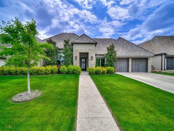 a front view of a house with a garden and yard