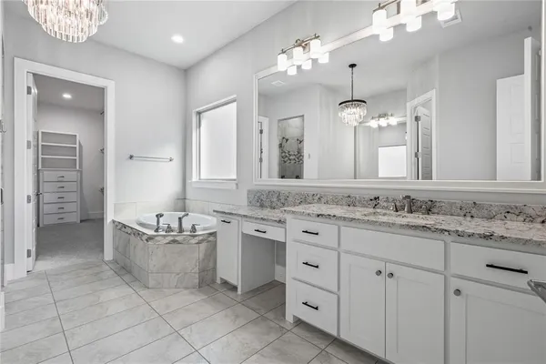 a bathroom with a granite countertop sink a large mirror a bathtub and