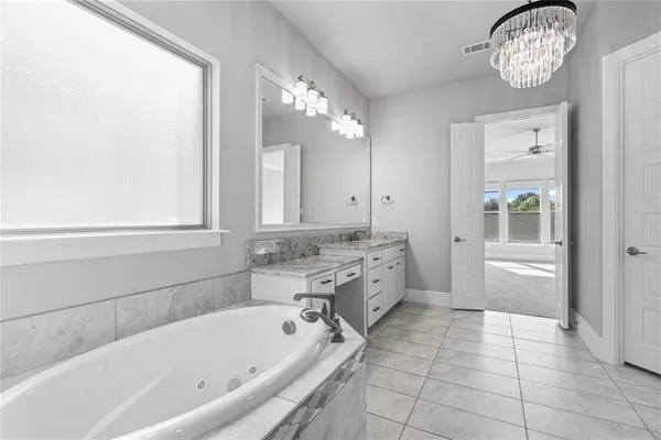 a bathroom with a bathtub a sink a mirror and a shower