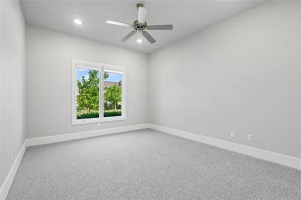 an empty room with a window and a ceiling fan