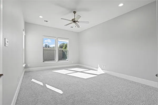en empty room with windows and chandelier fan