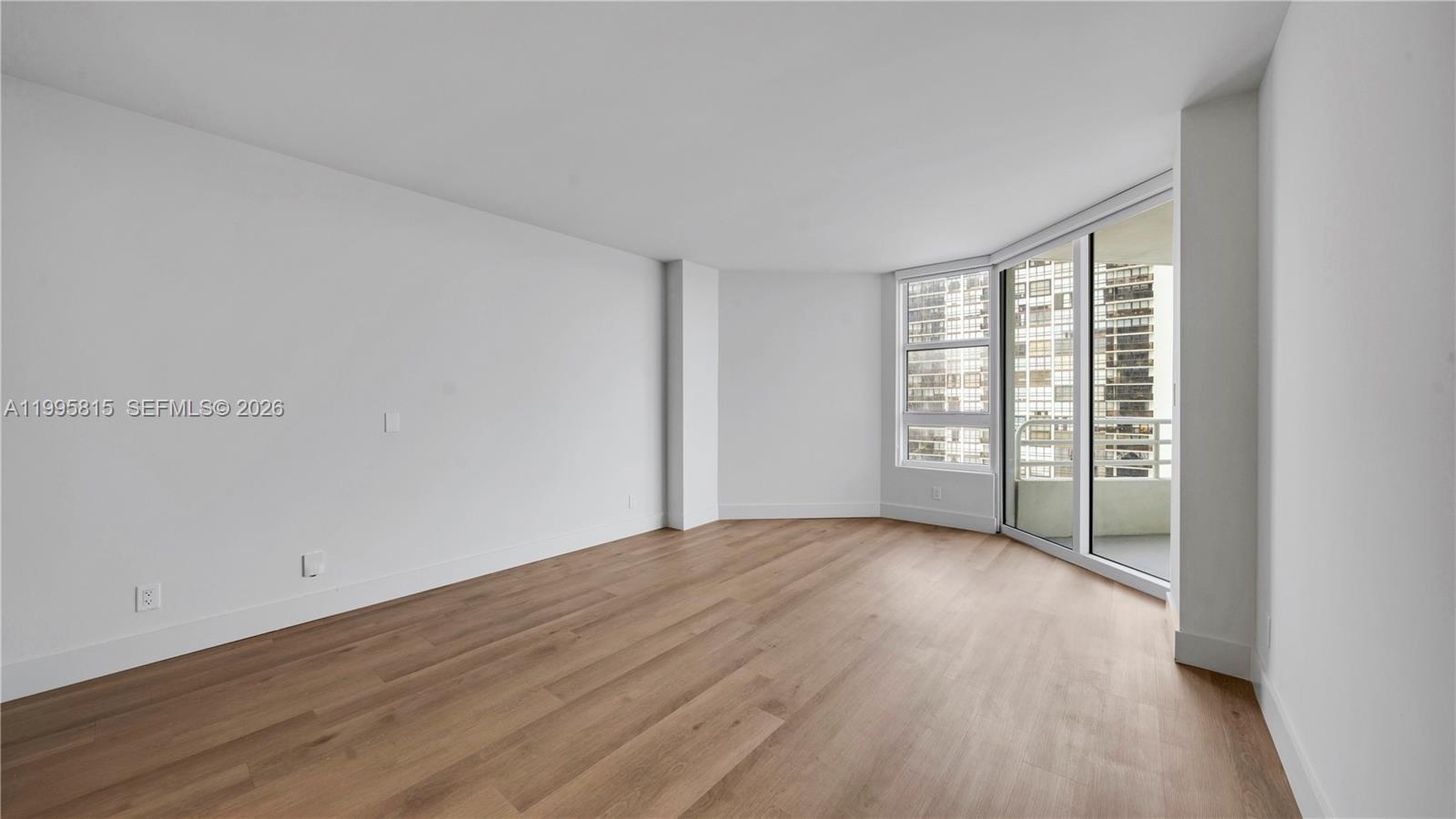 555 Northeast 34th Street, Unit 204 Miami, FL 33137 - Photo 14 of 31 an empty room with wooden floor and windows