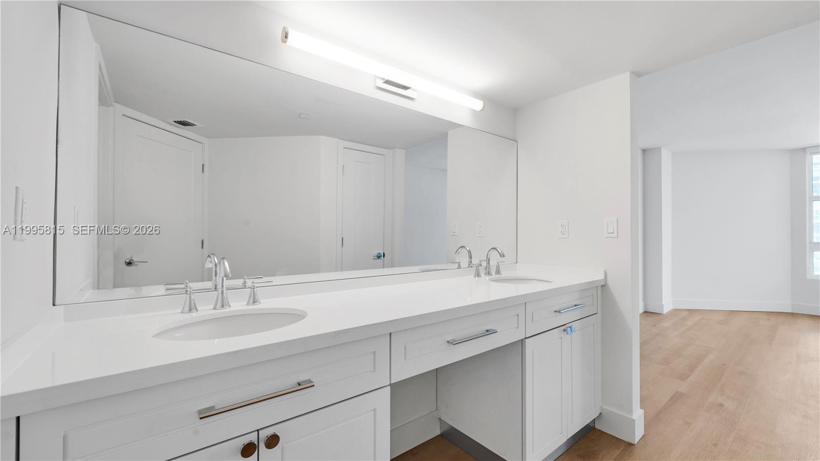 555 Northeast 34th Street, Unit 204 Miami, FL 33137 - Photo 19 of 31 a bathroom with a sink double vanity and a mirror