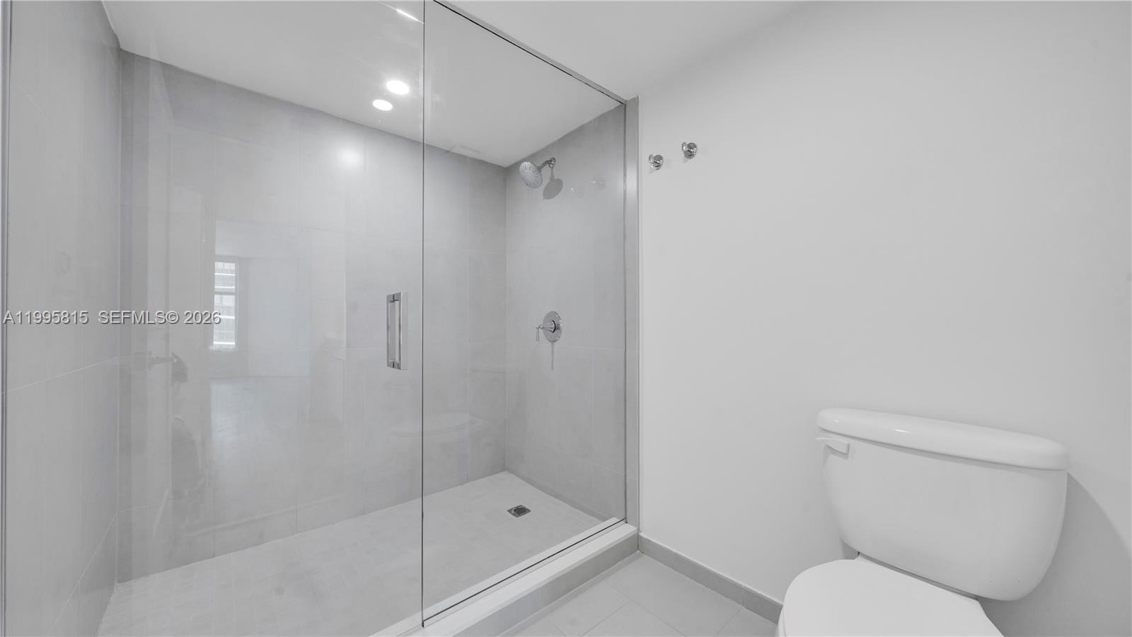 555 Northeast 34th Street, Unit 204 Miami, FL 33137 - Photo 20 of 31 a bathroom with a shower a toilet and sink