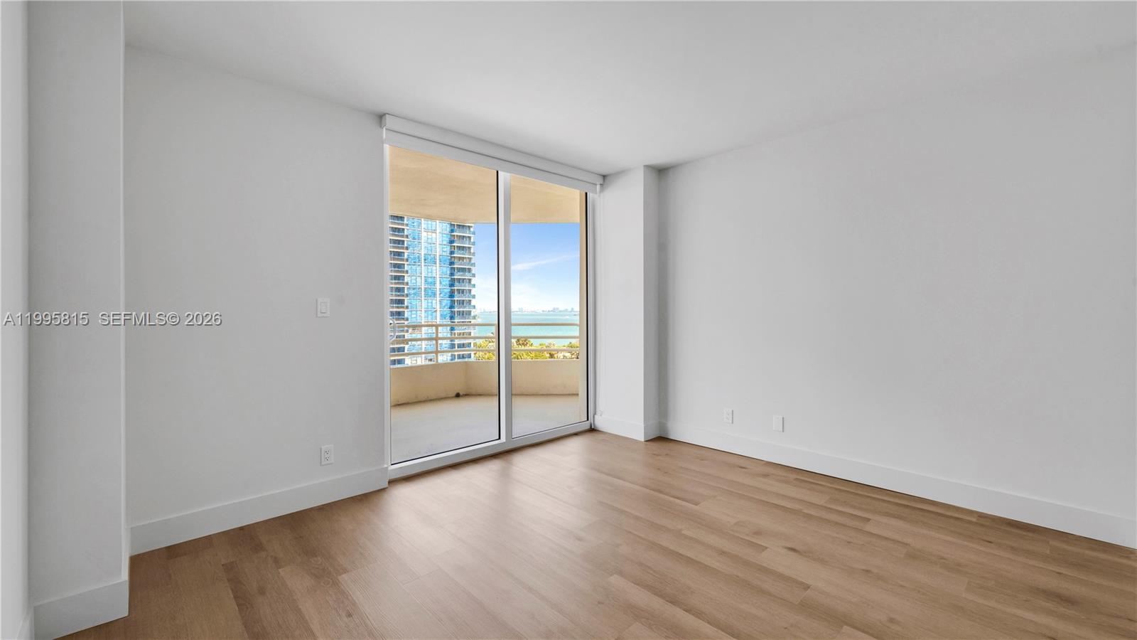 555 Northeast 34th Street, Unit 204 Miami, FL 33137 - Photo 28 of 31 a view of an empty room with wooden floor and a window