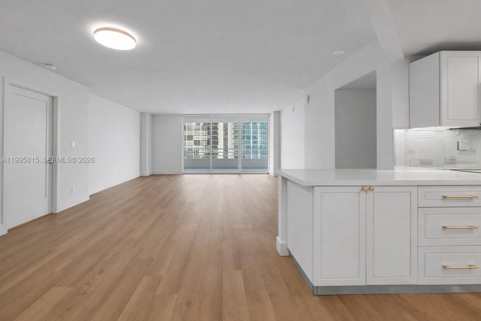 555 Northeast 34th Street, Unit 204 Miami, FL 33137 - Photo 31 of 31 a kitchen with white cabinets and wooden floor