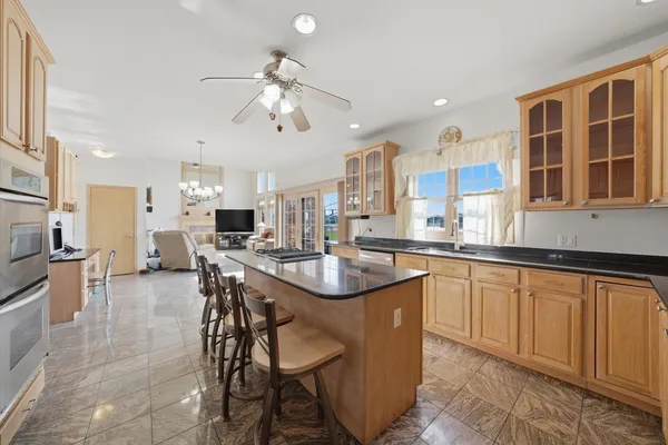 a kitchen with stainless steel appliances kitchen island granite countertop a refrigerator and a stove top oven