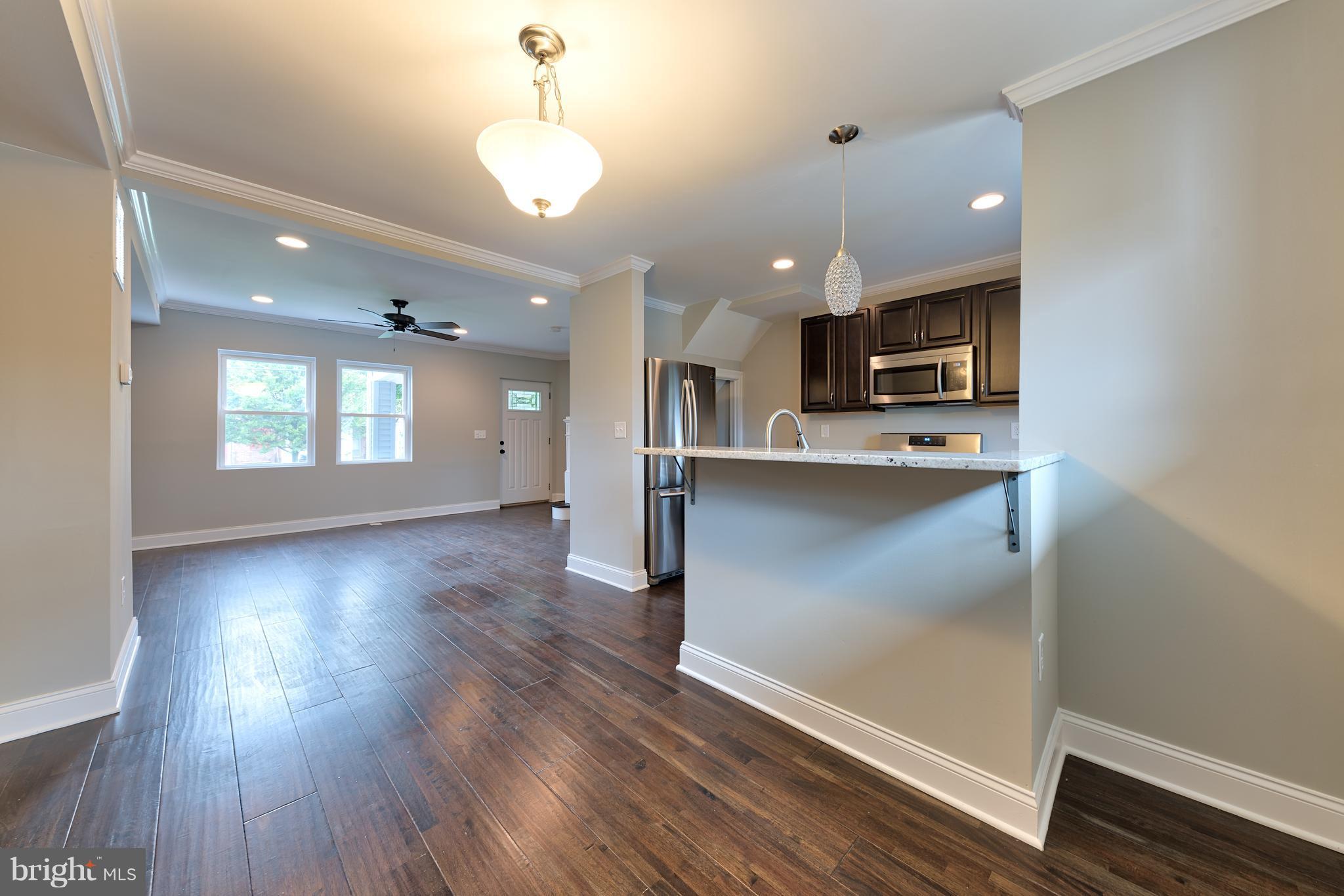 a view of kitchen with sink microwave and wooden floor