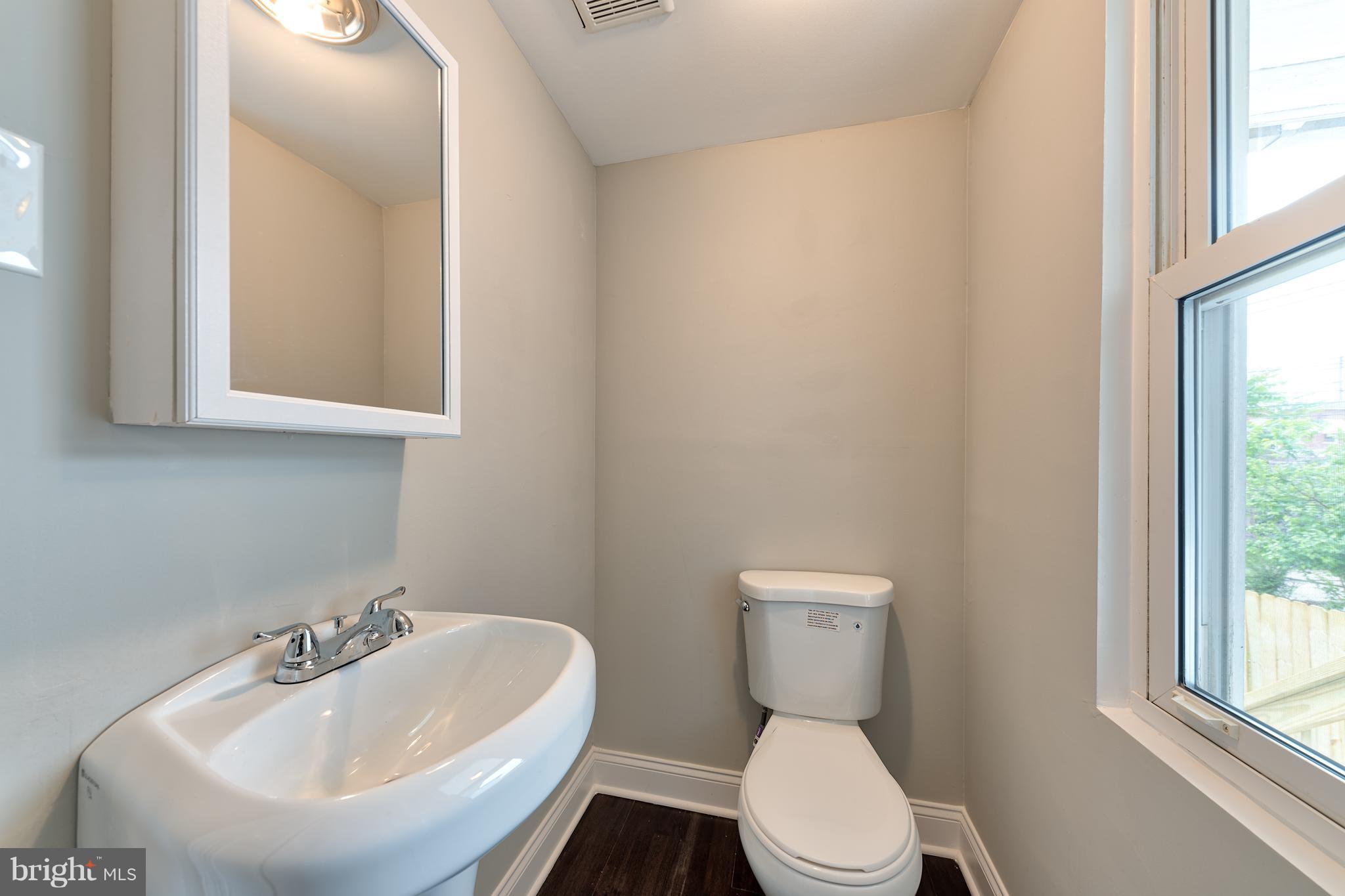 99 Willow Spring Road Baltimore, MD 21222 - Photo 11 of 30 a bathroom with a sink a toilet and mirror