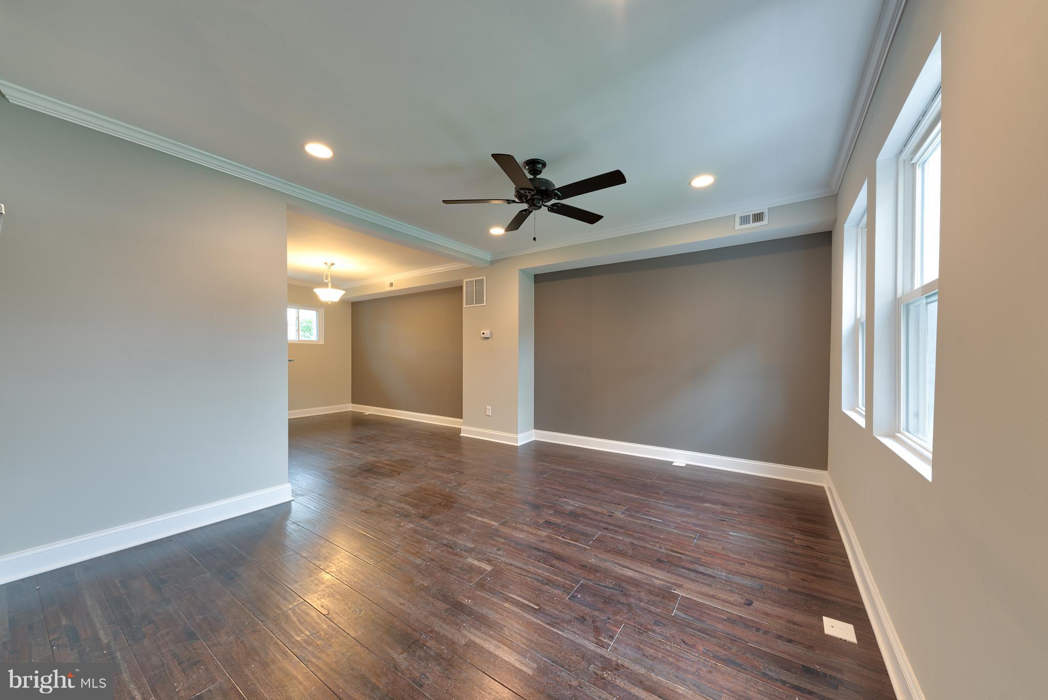 99 Willow Spring Road Baltimore, MD 21222 - Photo 5 of 30 wooden floor in an empty room with a window