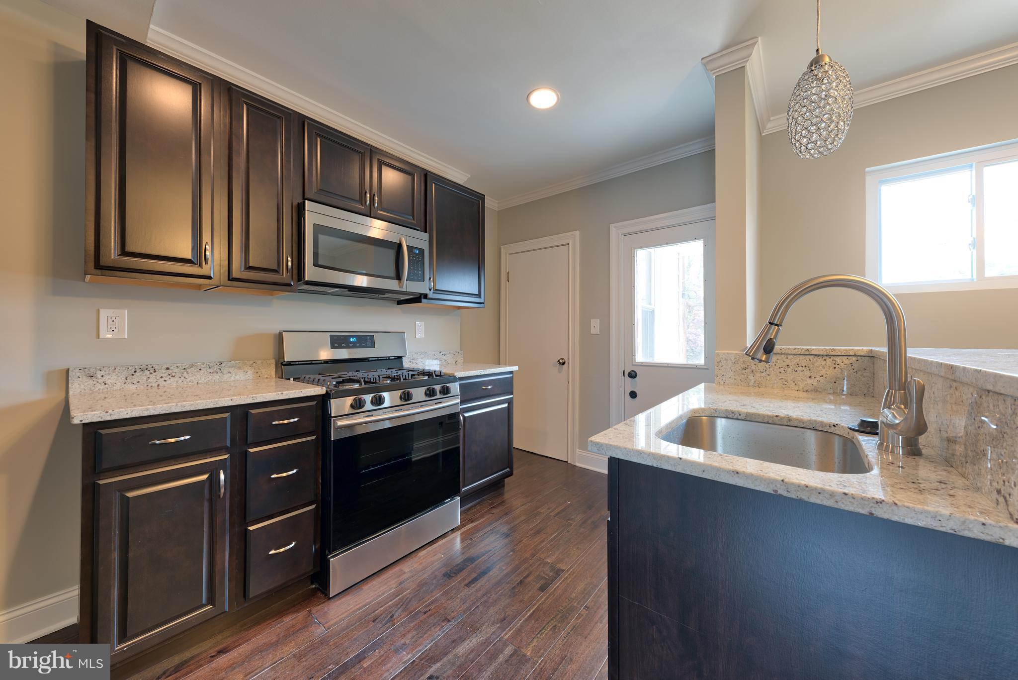 99 Willow Spring Road Baltimore, MD 21222 - Photo 8 of 30 a kitchen with stainless steel appliances granite countertop a sink and a stove top oven