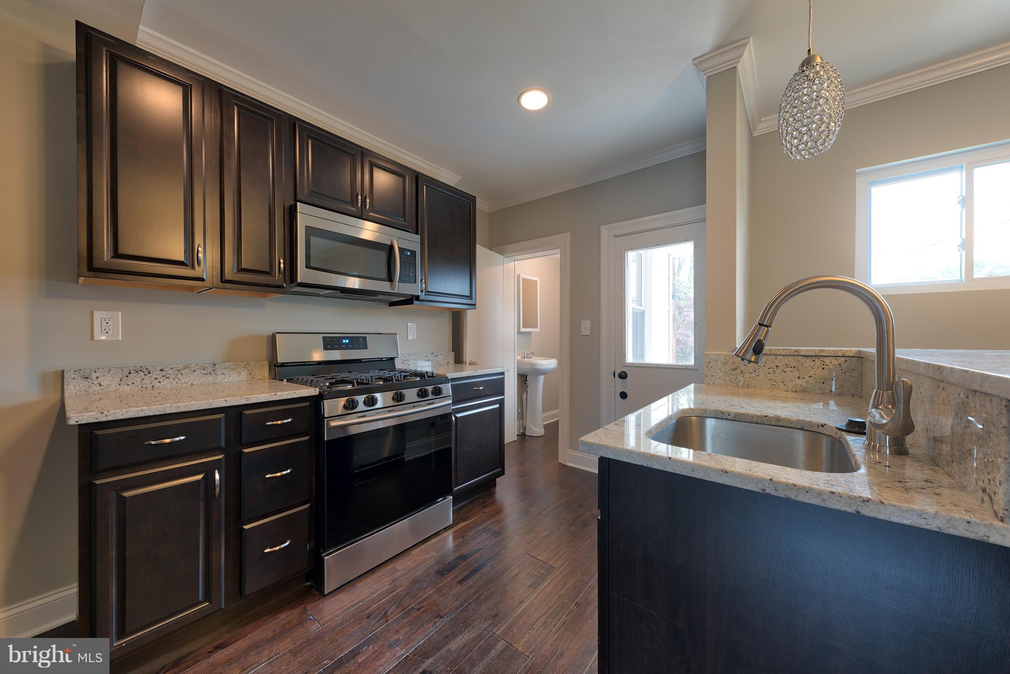 99 Willow Spring Road Baltimore, MD 21222 - Photo 9 of 30 a kitchen with stainless steel appliances granite countertop a sink and a stove top oven