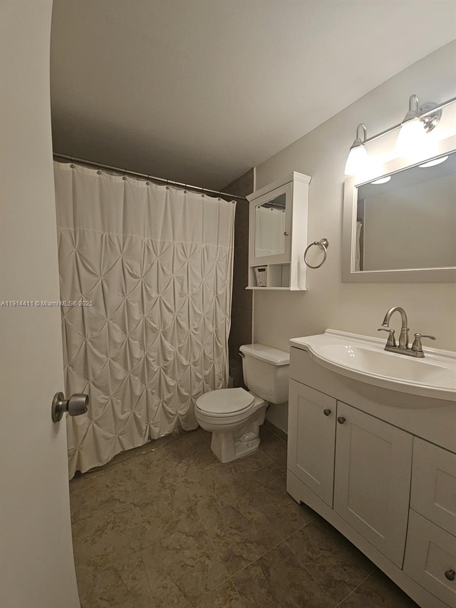 7870 Southwest 102nd Lane Miami, FL 33156 - Photo 27 of 41 a bathroom with a granite countertop sink a toilet and a mirror