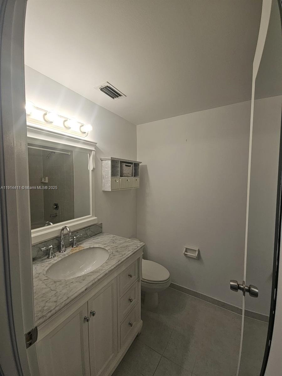 7870 Southwest 102nd Lane Miami, FL 33156 - Photo 34 of 41 a bathroom with a granite countertop sink toilet and a mirror