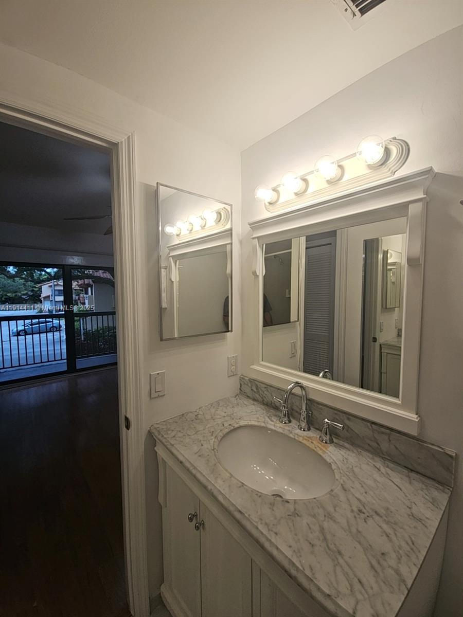 7870 Southwest 102nd Lane Miami, FL 33156 - Photo 36 of 41 a bathroom with a granite countertop sink a mirror and a vanity