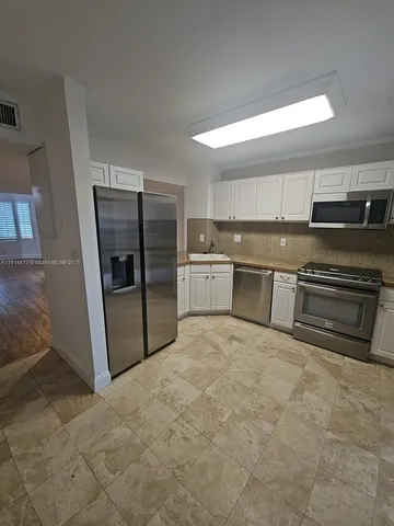 a large kitchen with cabinets and stainless steel appliances