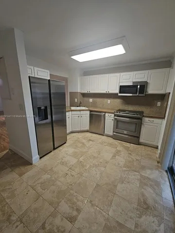 a room with a refrigerator and a sink