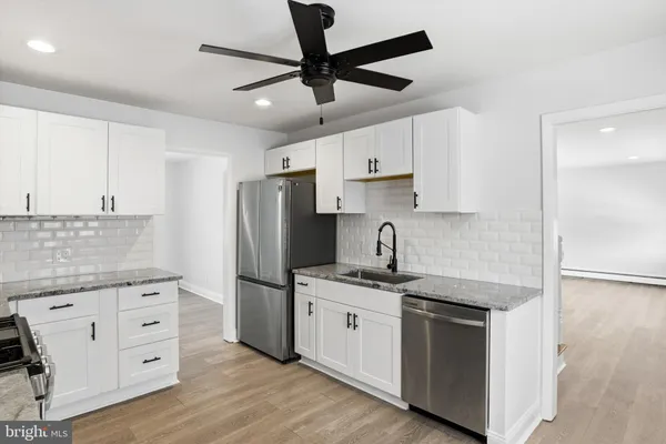 a kitchen with kitchen island granite countertop a sink appliances cabinets and counter space