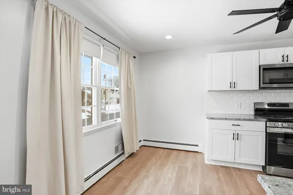 a view of a kitchen with wooden floor and electronic appliances