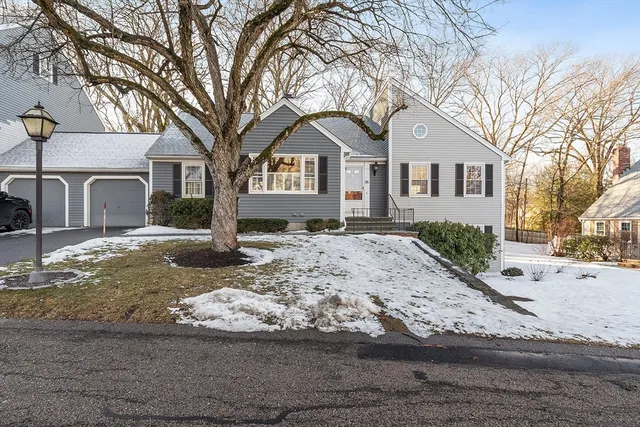 a front view of a house with a yard covered in snow