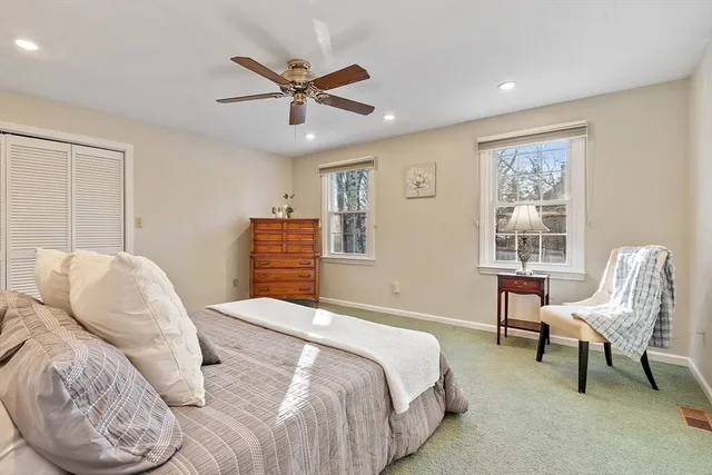 a bedroom with a large bed and a ceiling fan