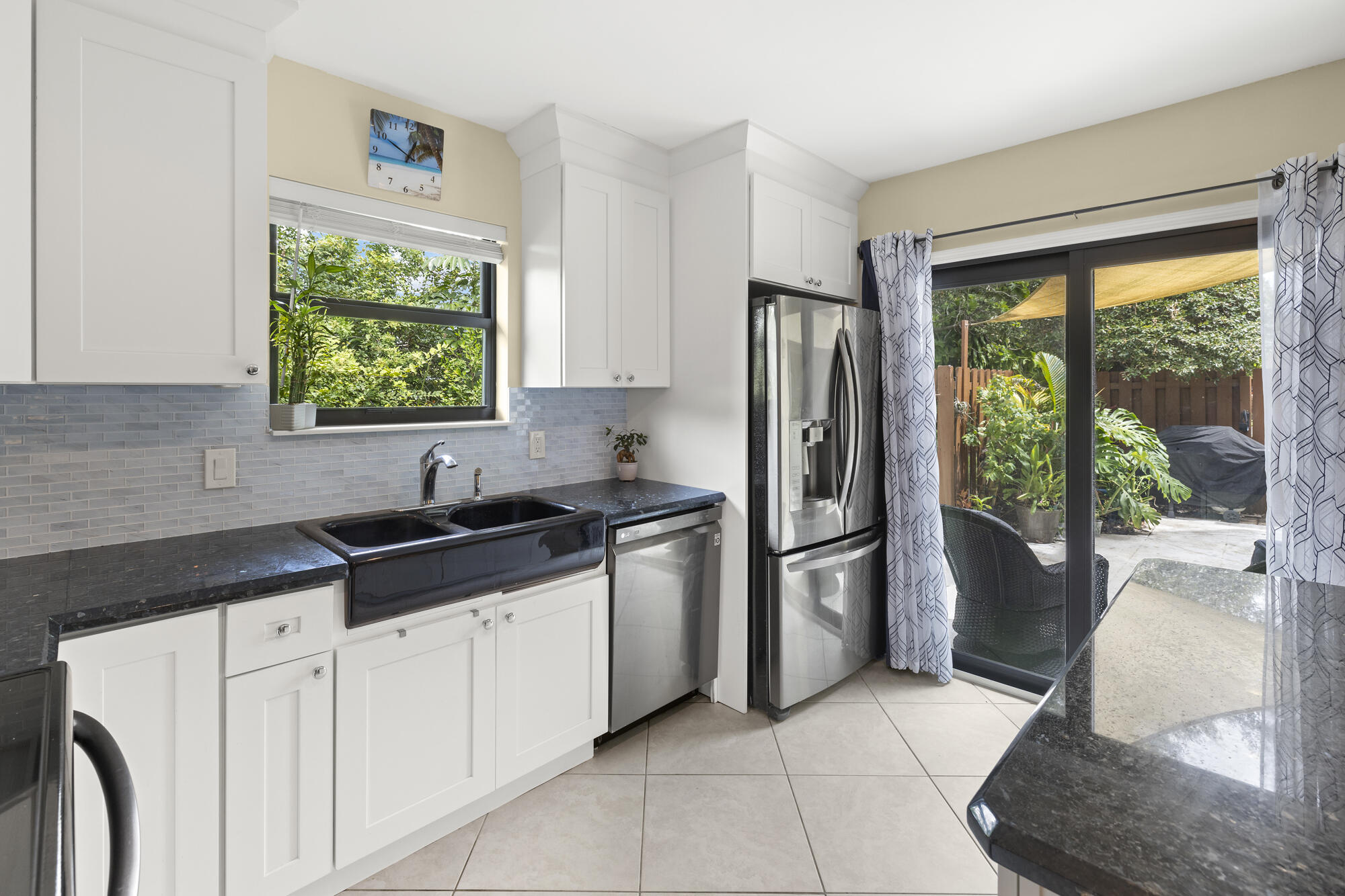 110 North Delaware Boulevard, Unit 18A Jupiter, FL 33458 - Photo 11 of 30 a kitchen with a sink a refrigerator and a stove top oven