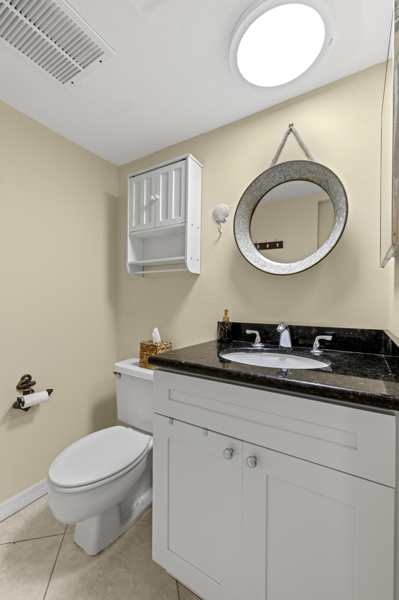 110 North Delaware Boulevard, Unit 18A Jupiter, FL 33458 - Photo 12 of 30 a bathroom with a toilet a sink and mirror