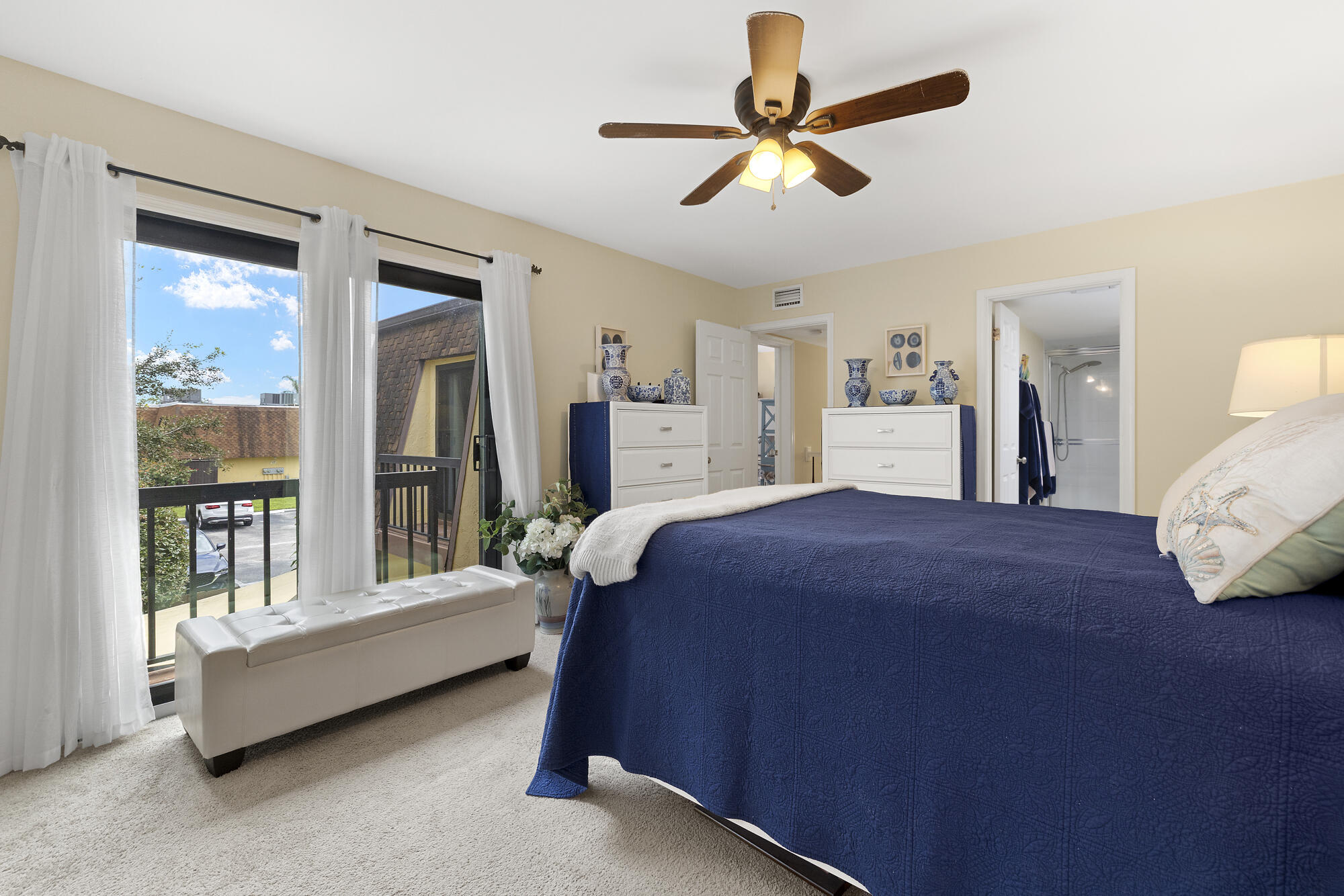 110 North Delaware Boulevard, Unit 18A Jupiter, FL 33458 - Photo 16 of 30 a bedroom with a large bed and a chandelier fan