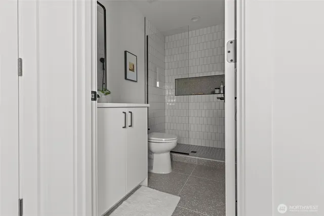 a bathroom with a granite countertop toilet a sink and a mirror