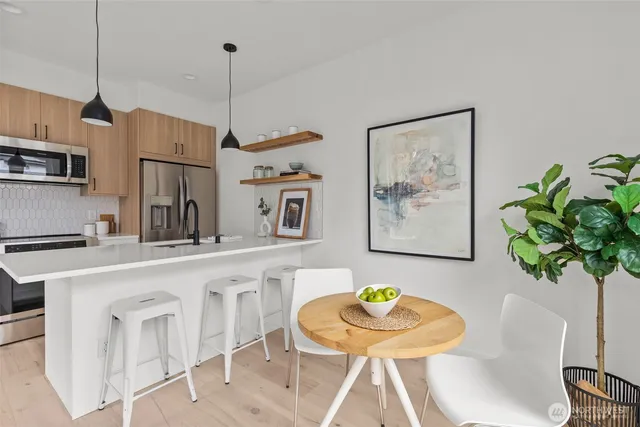 a kitchen with stainless steel appliances granite countertop a sink and a refrigerator