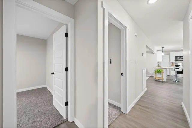 a view of a hallway with wooden floor windows and a living room