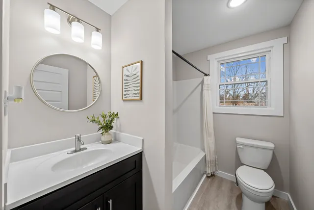 a bathroom with a toilet a sink a mirror and a bathtub