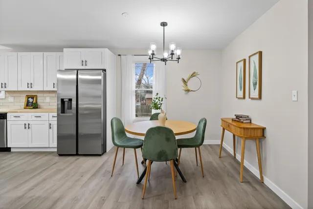 a view of a dining room with furniture a chandelier and wooden floor