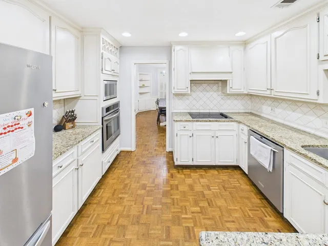 a large kitchen with cabinets and wooden floor