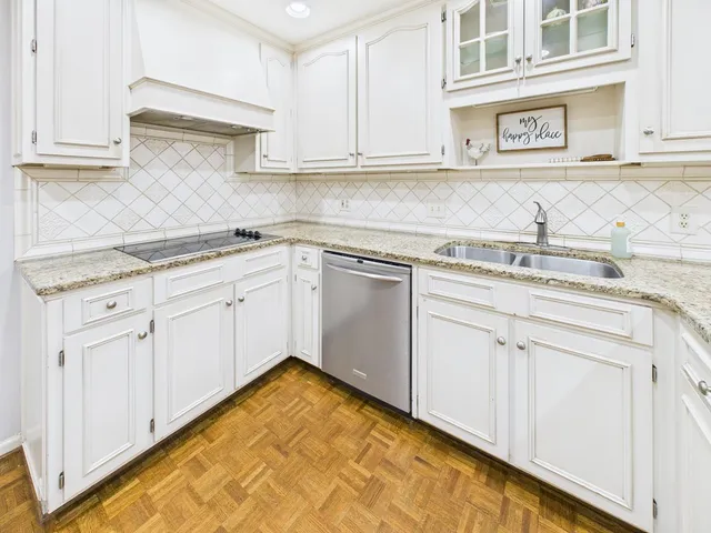 a kitchen with granite countertop white cabinets and sink
