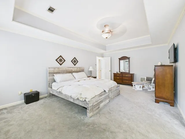 a spacious bedroom with a bed and a chandelier