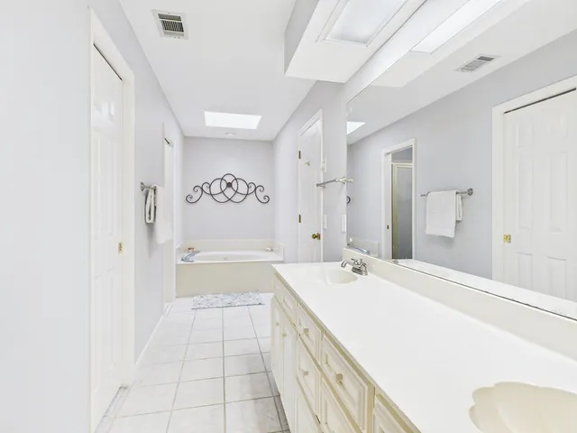 a spacious bathroom with a sink a mirror and a bathtub
