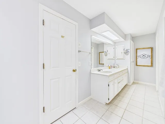 a large white bathroom with a sink a mirror and a bathtub