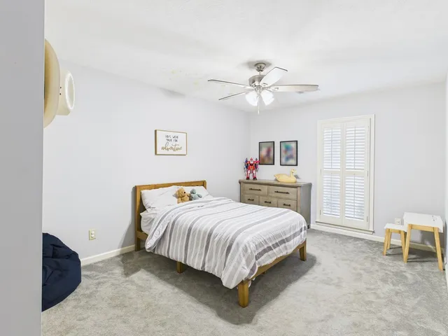 a bedroom with a bed chandelier and a window