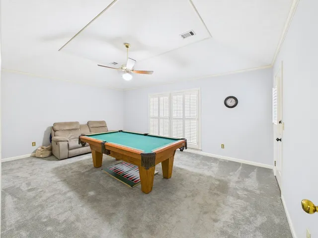 a room with pool table and windows