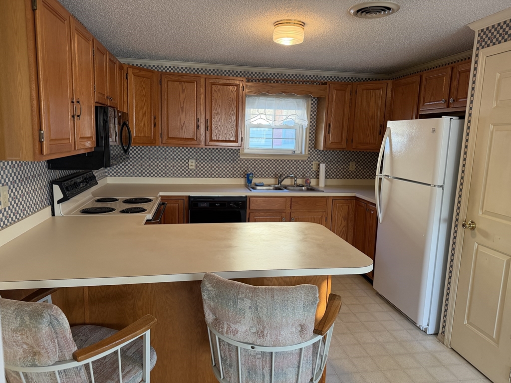 5 Virginia Avenue Marlborough, MA 01752 - Photo 7 of 19 a kitchen with a table chairs a refrigerator and a sink