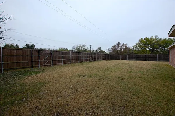 a view of a yard with a wooden fence