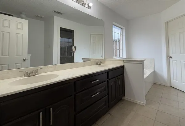 a bathroom with a double vanity sink and mirror