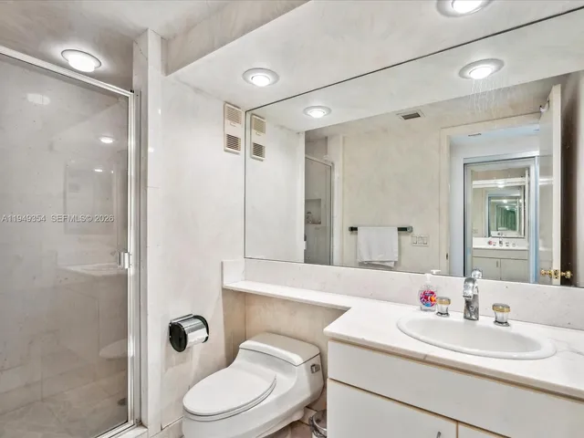 a bathroom with a sink toilet vanity and shower