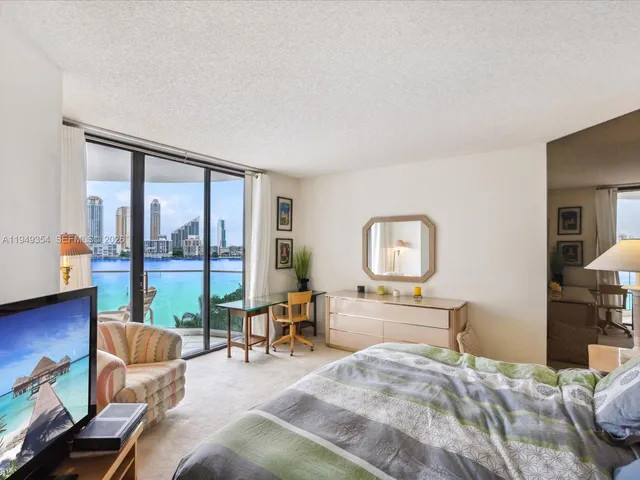 a bedroom with furniture and a large window