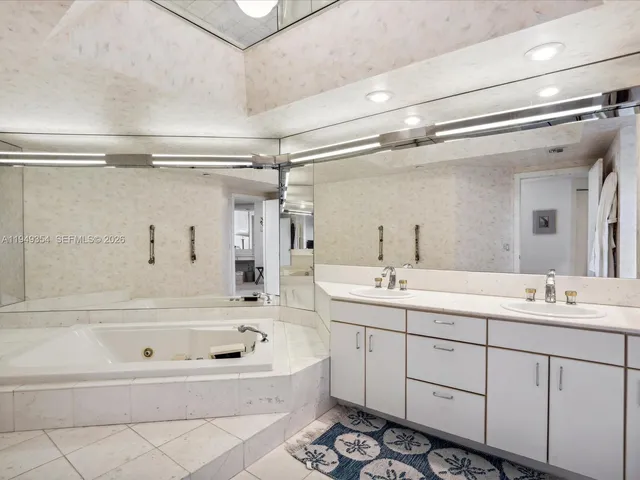 a bathroom with a tub a sink and mirror