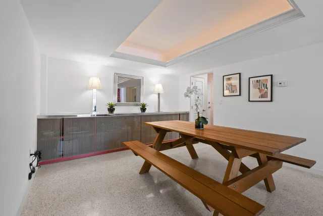 a living room with a table chairs and kitchen view