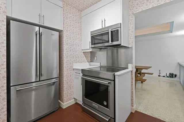 a kitchen with stainless steel appliances granite countertop a refrigerator and a sink
