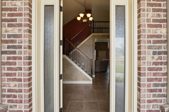 2567 West Rim Rock Drive Stockton, UT 84071 - Photo 6 of 64 Entryway featuring brick-clad exterior columns and a substantial wood door with frosted glass sidelights